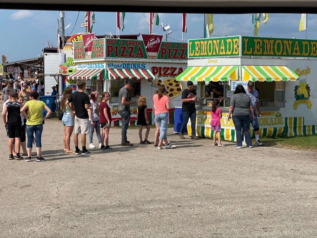 Nagel's Foods pizza trailer serving a line of customers at the fair.